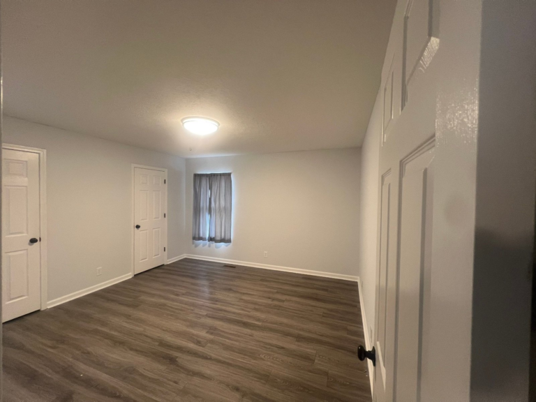Empty bedroom freshly repainted light gray with white trim