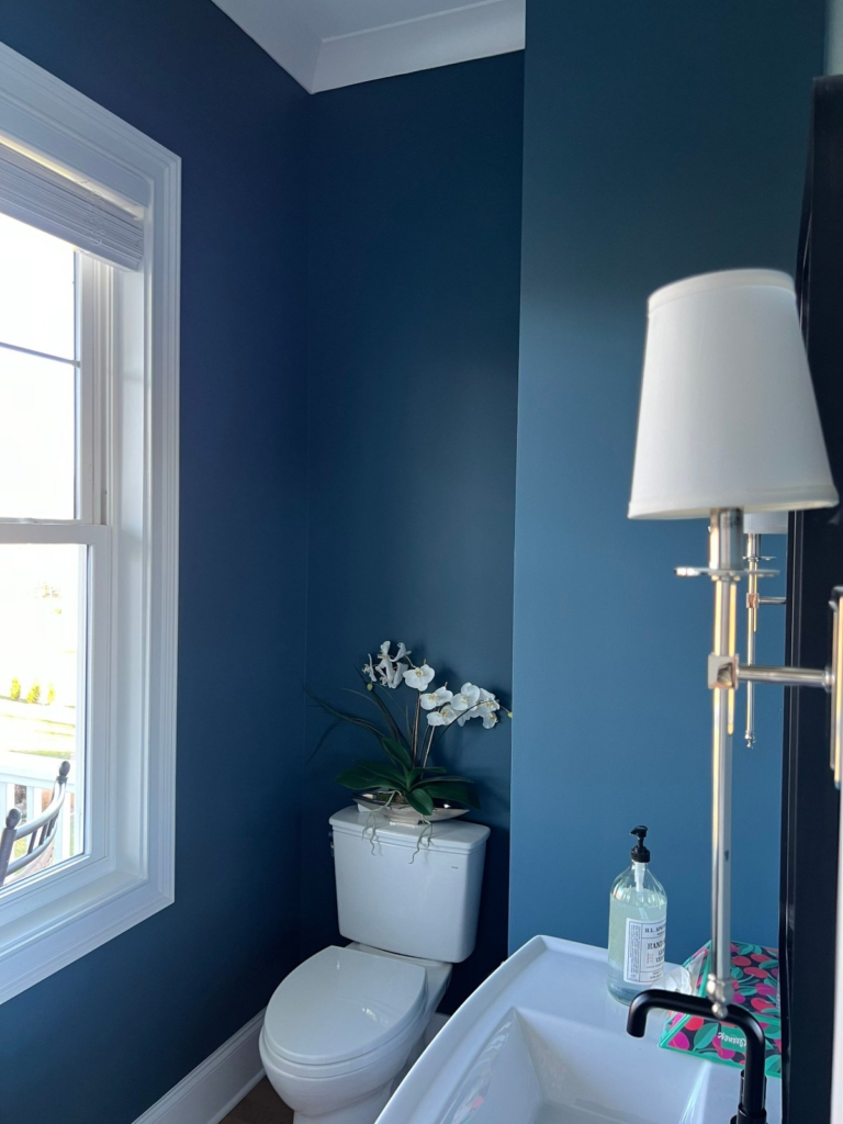 Powder room painted a rich blue with white trim