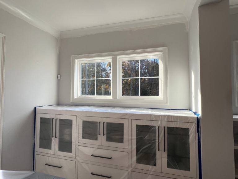 Built-in cabinets wrapped in plastic and floors masked before painting