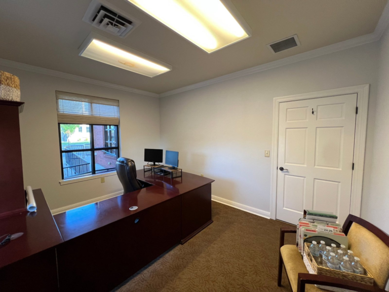 Repainted commercial office showing finished walls, trim and a painted six-panel door