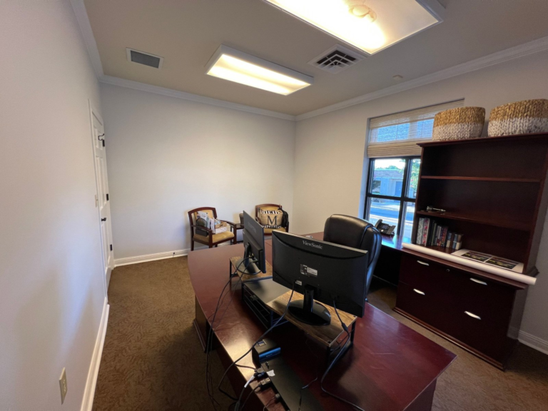 Repainted commercial office with window wall and built-in shelving