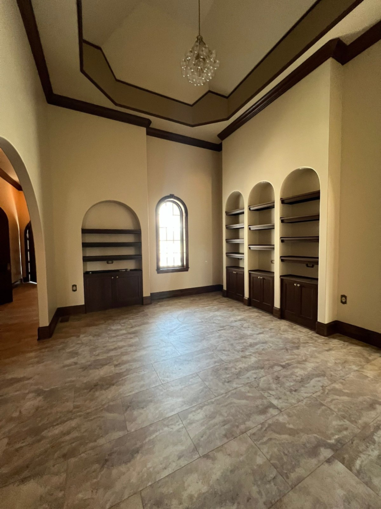 Library with arched built-ins, freshly painted walls and coffered ceiling