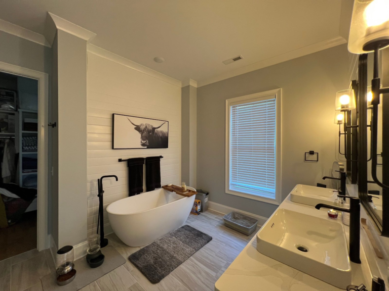 Primary bathroom with soft gray walls, shiplap and white crown molding