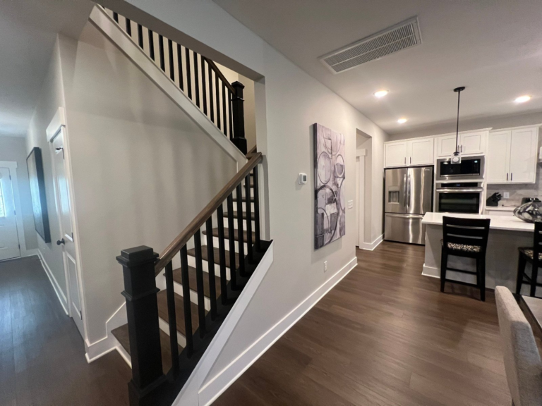 Open stairwell and living room with fresh gray walls and white trim