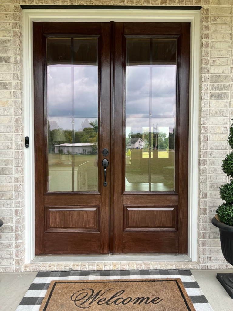 Refinished dark-stained double front doors with glass panels