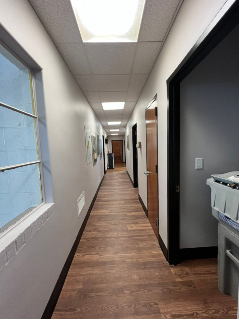 Long office corridor repainted with contrasting dark trim and door frames