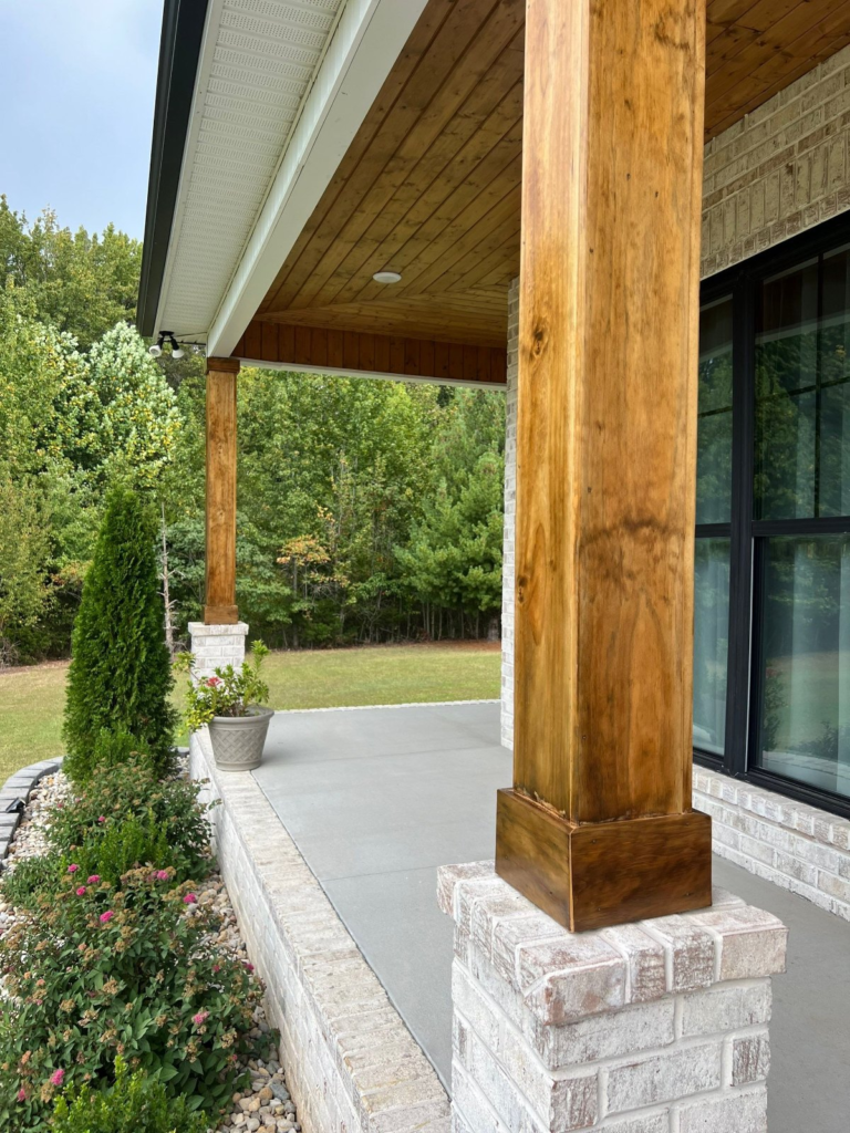 Freshly stained cedar porch column on a stone base