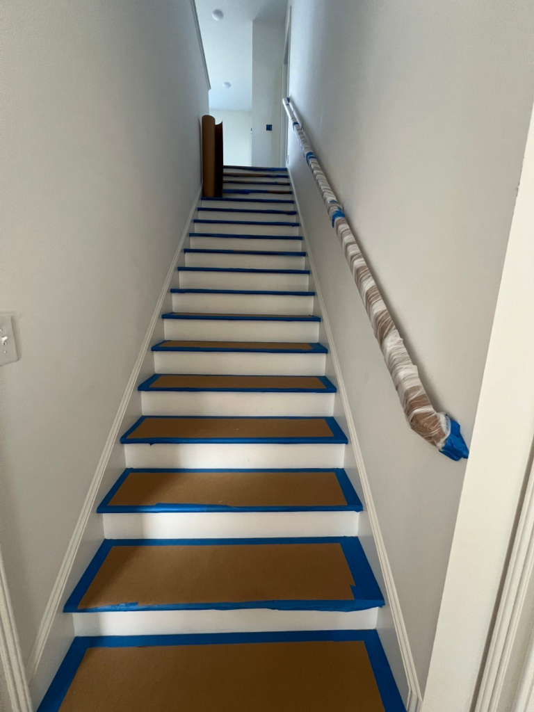 Stair treads and handrail protected with paper and painter's tape
